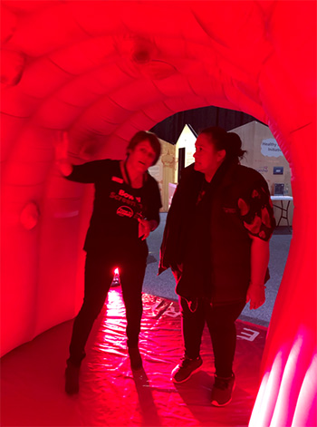 Two Forum 2019 participants stand inside the inflatable bowel which is designed to show the progression of bowel cancer from small polyps to advanced tumours